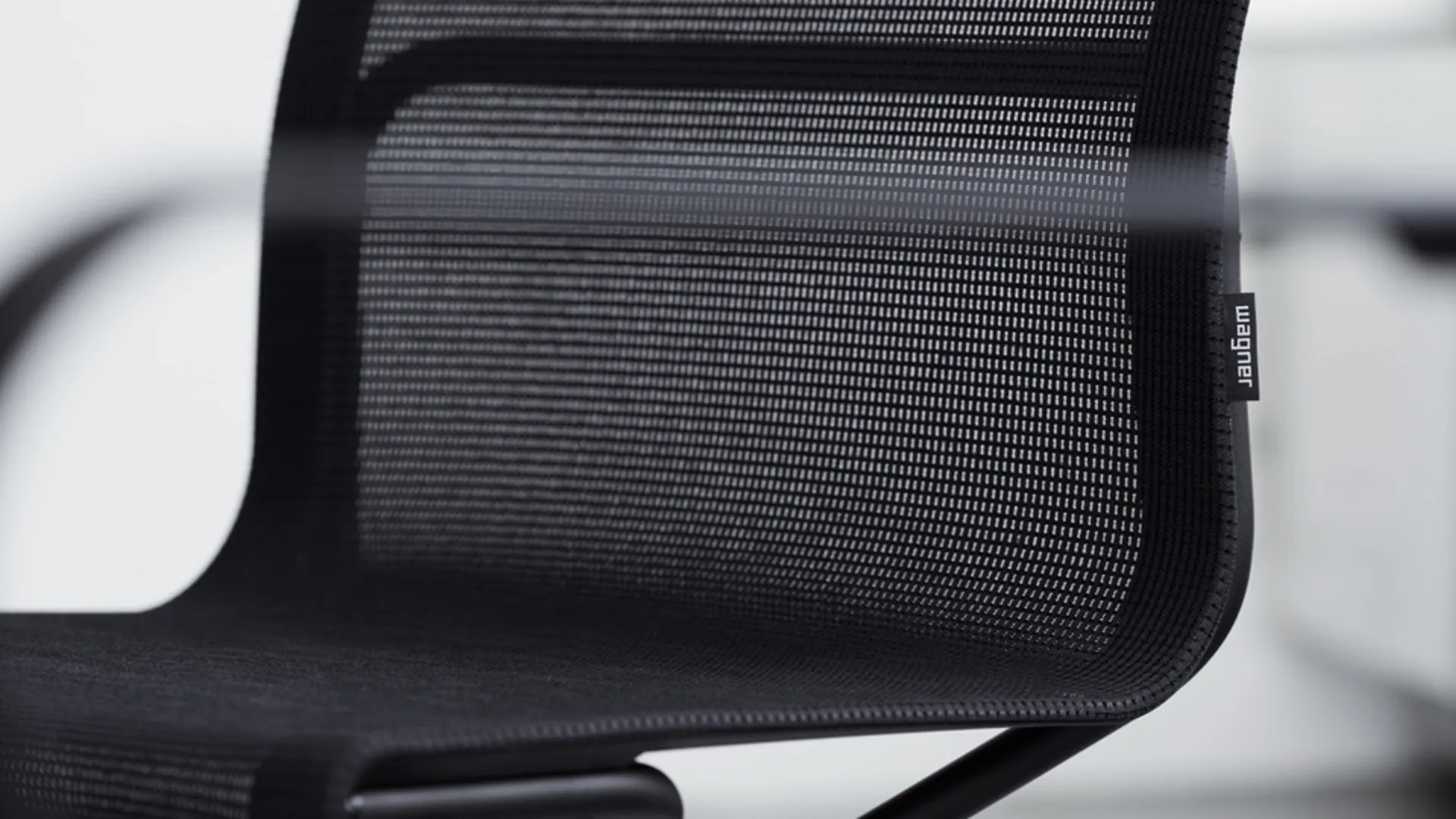 Detail of a black office chair with a mesh backrest Detail of a black office chair with a mesh backrest