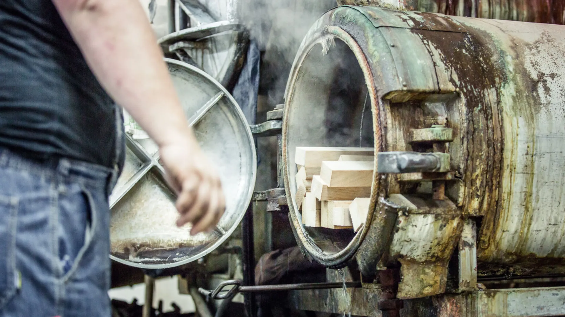 Craftsman working on a machine with a large wheel Craftsman working on a machine with a large wheel