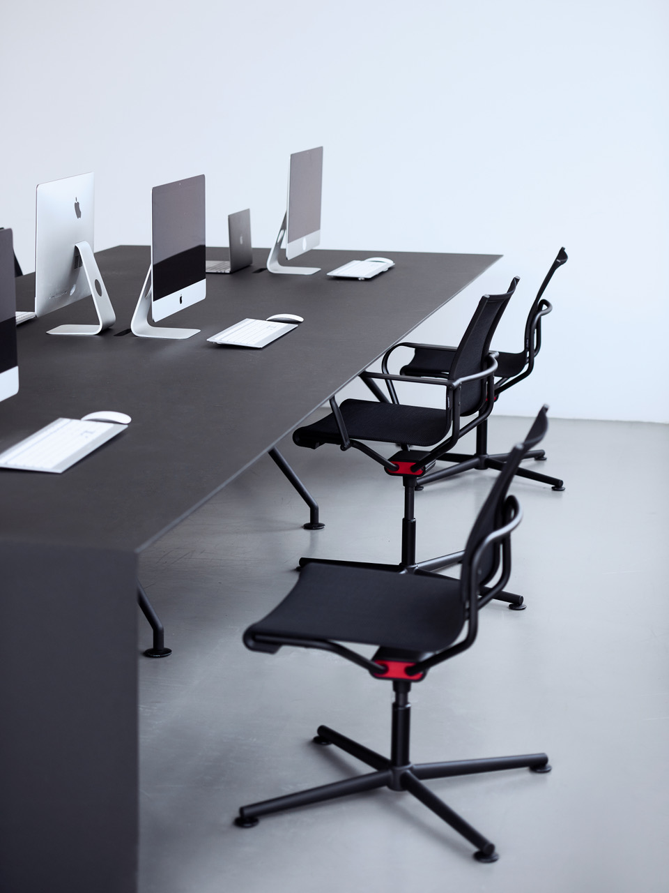 Schwarze Bürostühle an einem Schreibtisch Schwarze Bürostühle an einem Schreibtisch